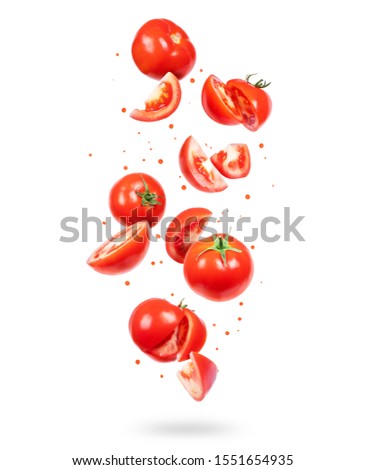 Whole and sliced fresh tomatoes in the air on a white background Royalty-Free Stock Photo #1551654935