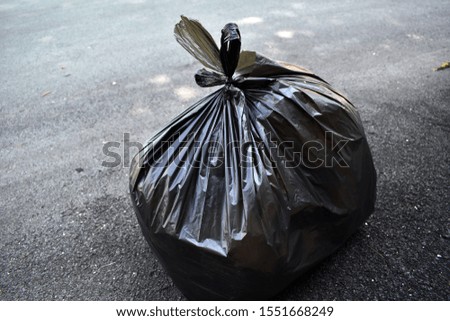 A  black garbage plastic bag was used to collected the waste materials for recycling .