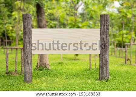 Blank weathered wooden sign with pine wood board in a park
