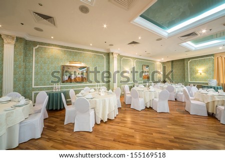 Beautiful hall with pictures and tables in a restaurant decorated for a wedding celebration,  in place of pictures photo by the author.