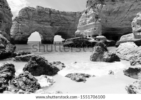 Portugal Atlantic coast landscape in Algarve region. Marinha Beach natural double arch. Black and white retro style.