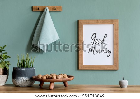 Interior design of dining room with mock up poster frame, kitchen accessories, plants, nuts and elegant accessories. Eucaltyptus color concept. Template. Ready to use. Stylish scandinavian home decor.
