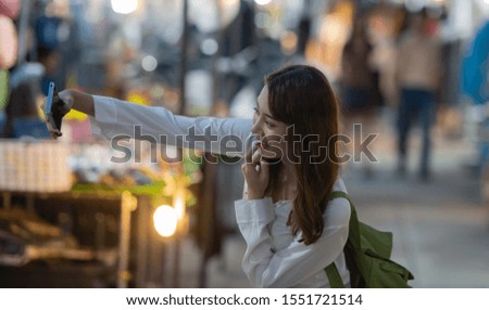 Travel woman with enjoying and take selfie with phone on city street