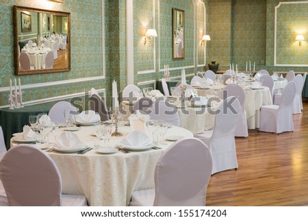 Elegant tables in a restaurant decorated for a wedding celebration,  in place of pictures photo by the author.