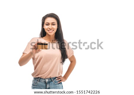 smiling african american woman standing with hand on hip and holding credit card isolated on white