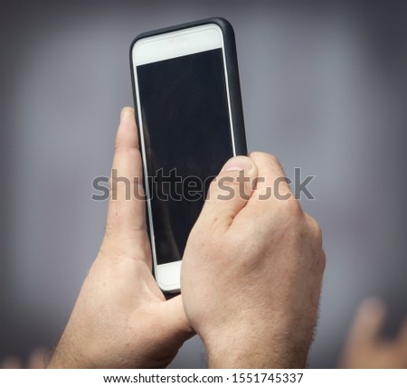 A man shoots a video on the phone.