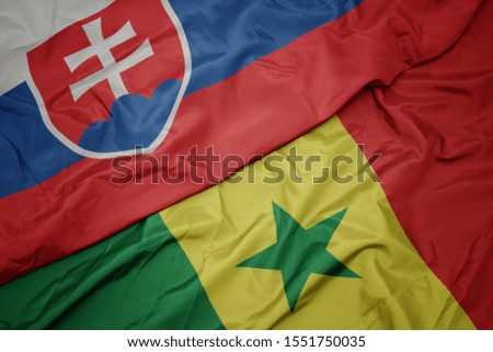 waving colorful flag of senegal and national flag of slovakia. macro