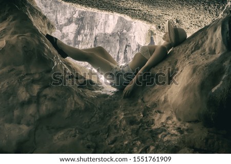 
girl lies on a stone in a cave