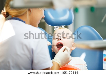 Four year old boy visits the dentist at her office for a check up.