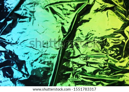 
Colored foil. Shiny blue green gradient background. Crumpled Foil Background
