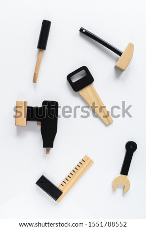 Children wooden tools on white background. The concept of diy. Saw, drill, screwdriver, hammer, key hexagon.