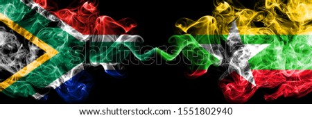 South Africa vs Myanmar smoky mystic flags placed side by side. Thick colored silky abstract smoke flags concept