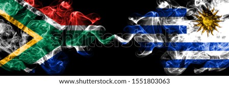 South Africa vs Uruguay, Uruguayan smoky mystic flags placed side by side. Thick colored silky abstract smoke flags concept