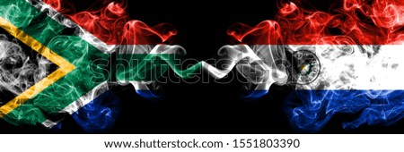 South Africa vs Paraguay, Paraguayan smoky mystic flags placed side by side. Thick colored silky abstract smoke flags concept