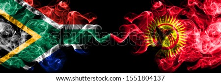 South Africa vs Kyrgyzstan smoky mystic flags placed side by side. Thick colored silky abstract smoke flags concept