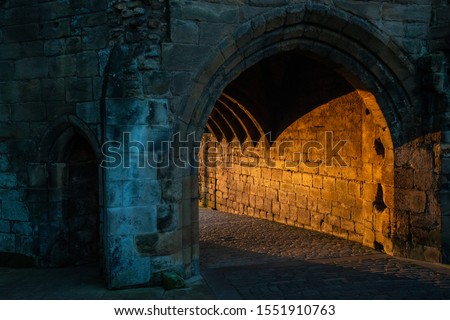Dunfermline Abbey gateway lit up with the suns rays at sunrise.