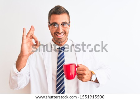 Young handsome therapist man drinking coffee over isolated background doing ok sign with fingers, excellent symbol