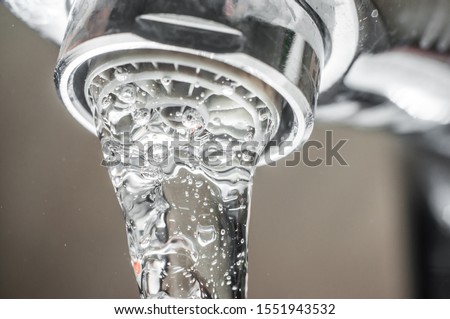 Frozen water stream from a tap Close-up. Aerator operation for saving water consumption. Royalty-Free Stock Photo #1551943532