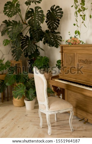  piano. a piano and a chair. the piano is decorated with flowers. 