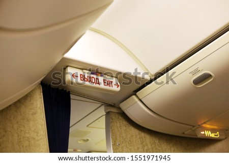 Signs lighting up inside airplane in safety reason. Exit, no smoking, lavatory, fasten seat belts.