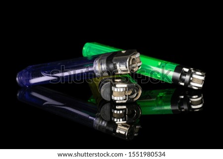 Group of three whole plastic lighter isolated on black glass