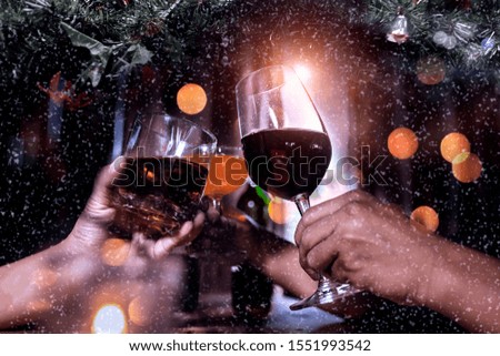 Snowflakes and Cheers clinking of friends in party, Christmas background. Soft focus.