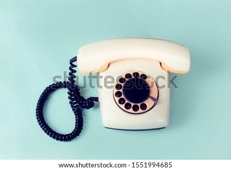 Retro telephone set with disk dialing on a blue background, film effect