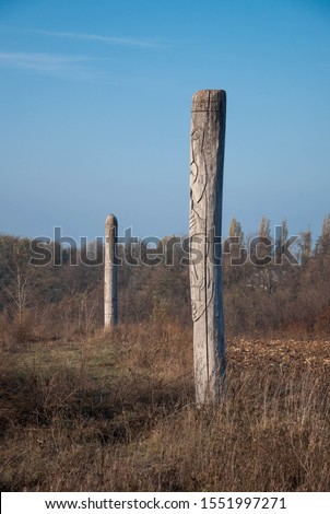 Wooden idol Slavic god Svarog on a background of blue sky