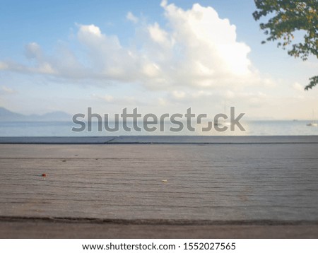 Picture of a wooden table with a blurry background in the sea The atmosphere in the morning and evening is still sunny. Is a natural concept and has space for characters. Copy space