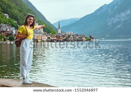 woman standing on the beach looking at hallstatt city