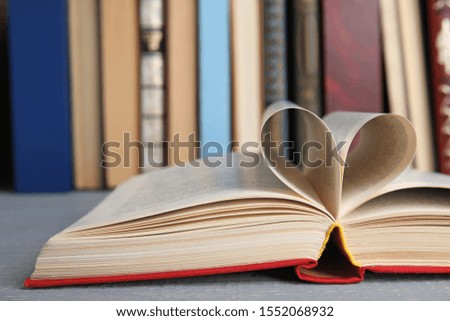 Open hardcover book on grey wooden table, closeup