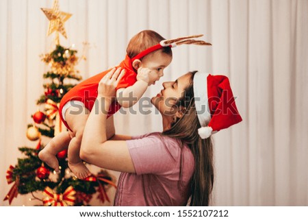 Mother and her baby playing at home on Christmas holiday