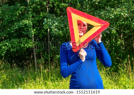 Woman with emergency stop sign vote on the road. Car insurance concept
