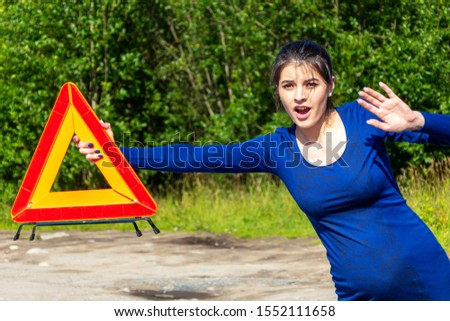 Woman with emergency stop sign vote on the road