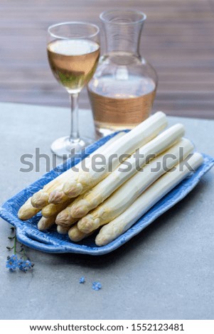 Fresh raw washed and peeled white asparagus vegetables ready to cook and rose wine