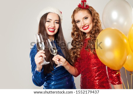 Christmas women with sparkling wine glasses. Happy smiling girls chin-chin
