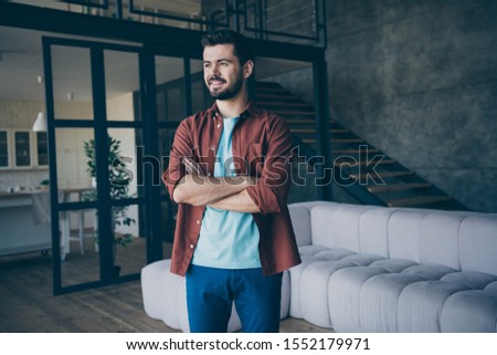 Profile side photo of positive cheerful bearded guy real optimistic entrepreneur dream he will have successful company start up cross hands wear casual style clothing in house indoors loft