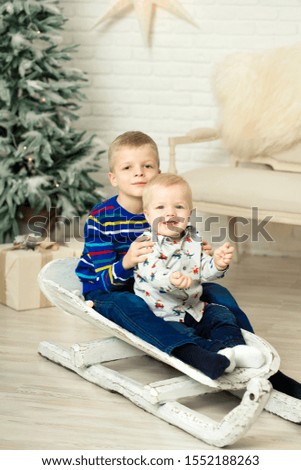 Christmas is already here. Two brothers sledding with christmas gift box. Small cute boy received holiday gifts. Kid hold gift box while sledding. Celebrate christmas. Winter activity.