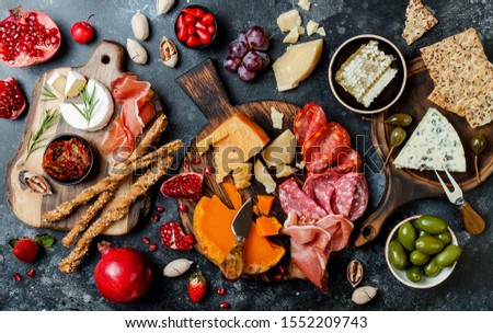 Appetizers table with italian antipasti snacks. Brushetta or authentic traditional spanish tapas set, cheese variety board over black stone background. Top view, flat lay Royalty-Free Stock Photo #1552209743