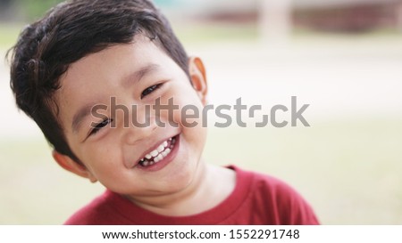 Young Asian boy, kid wears a red T-shirt, 2 years old, smiling, cute, showing beautiful teeth.
Can use the pictures to sell insurance or oral and dental health concept.                               