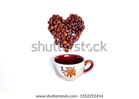 A picture of coffee beans I heart shape with cup of coffee. Love coffee for romance concept.