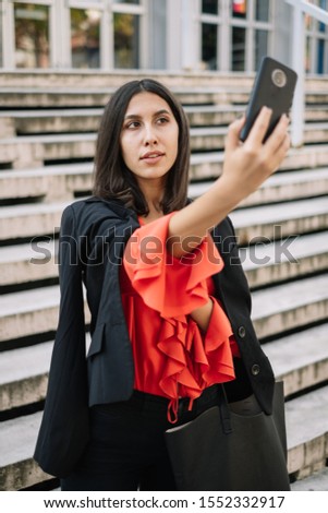 Brunette woman posing for selfie at stairs