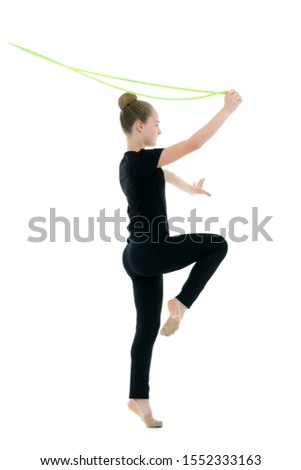 A girl gymnast performs exercises with a skipping rope.