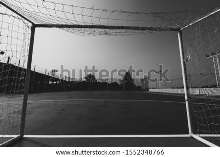 View of a football field in the frame of the goal.black and white picture.