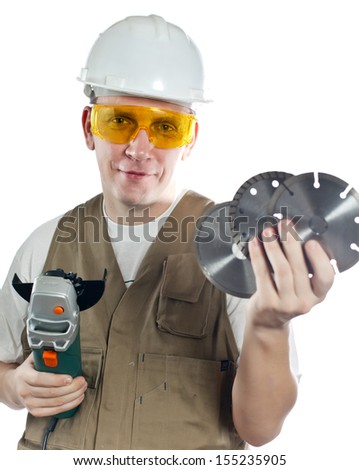 The man in working overalls in goggles and a helmet with the detachable machine and saw disks 