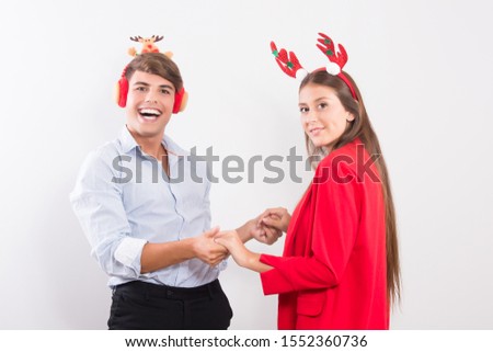 Happy young Latin couple in love having a good time in Christmas Day in red hats fun and happy on face isolated on white background with copy space Happy New Year 2020 celebration concept.