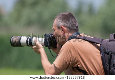 Photographer in action with  telephoto lens
