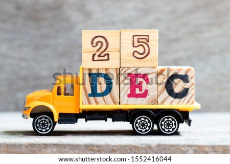 Truck hold letter block in word 25dec on wood background (Concept for date 25 month December , Christmas)