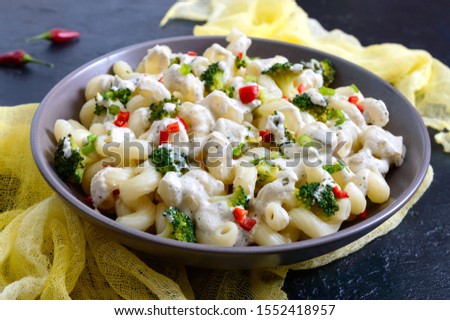 Cavatappi pasta with broccoli, red pepper and cream sauce in a bowl. Vegetarian dish. Delicious wholesome food. Proper nutrition. Royalty-Free Stock Photo #1552418957