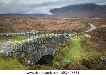 This is a small old stone bridge in Glencoe in the Scottish Highlands that is part of the West Highland Way Royalty-Free Stock Photo #1552426664